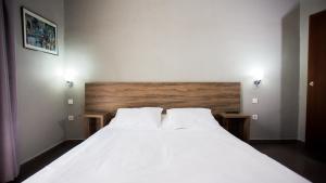 Hôtel Olympic في فاس: غرفة نوم بسرير ابيض مع وسادتين