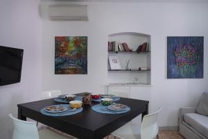 Casa Artè by Wonderful Italy في سانتا مارغريتا ليغور: طاولة سوداء مع أطباق من الطعام عليها في غرفة المعيشة