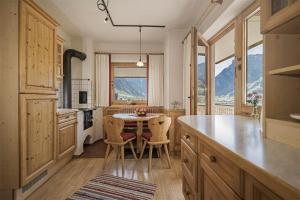 a kitchen with a table and chairs and mountains at Apart. Mountainlovers in Hainzenberg