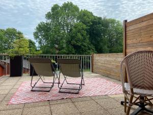 zwei Stühle auf einem Teppich auf einer Terrasse in der Unterkunft Logis Hôtel & Restaurant - Le Relais de Montigny in Montigny