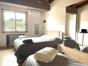 a bedroom with three beds and a window at Andi Casa - Sicilia - vista mare in Santa Teresa di Riva