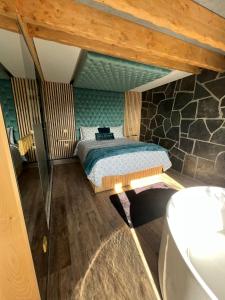 een slaapkamer met een bed en een stenen muur bij Muas Guest House in Vila Real