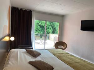 a hotel room with a bed and a large window at Logis Hôtel & Restaurant - Le Relais de Montigny in Montigny