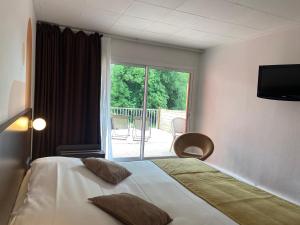 Cette chambre comprend un lit et une grande fenêtre. dans l'établissement Logis Hôtel & Restaurant - Le Relais de Montigny, à Montigny