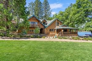 a log home with a deck and a house at Marina Beach Lodge - Lakefront Home on Beach! home in Groveland