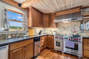 una cocina con armarios de madera y electrodomésticos de acero inoxidable en Marina Beach Lodge - Lakefront Home on Beach! home, en Groveland