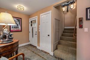 a hallway with stairs and a door and a lamp at Marina Beach Lodge - Lakefront Home on Beach! home in Groveland