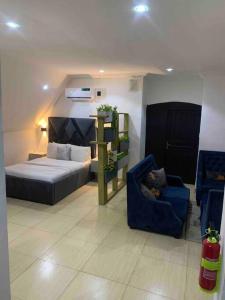 a bedroom with a bed and a blue chair at Loft Studio Unit in Lekki phase 1 - 2 ACs, Kitchen, Closet & Ironing room, Netflix, WI-FI, Bath tub 1 in Lagos