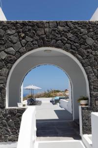 un arco en una pared de piedra con un patio en White Element en Karterados