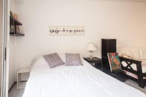 1 dormitorio con 1 cama blanca y 2 almohadas en STUDIO Fitz Roy - By HART en Buenos Aires