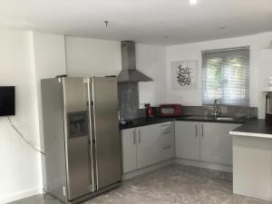 a kitchen with a stainless steel refrigerator and a sink at Furze Cottages in Buckinghamshire