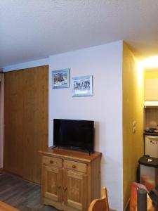 a living room with a flat screen tv on a wooden cabinet at Appartement valmeinier 6 personnes in Valmeinier