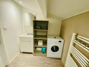 a small bathroom with a washing machine and a sink at ''L'Amandier'' Cosy T2 en coeur de ville, climatisé in Sète