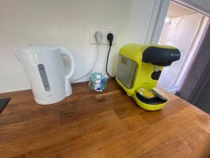a small yellow appliance sitting on top of a wooden floor at ''L'Amandier'' Cosy T2 en coeur de ville, climatisé in Sète +2 photos