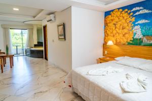 a bedroom with a bed and a painting on the wall at Los Lagos Resort Hotel in Capiatá