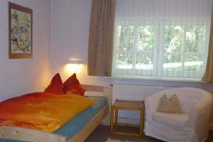 1 dormitorio con 1 cama, 1 silla y 1 ventana en Ferienwohnung Niemann in Lutterloh, en Unterlüß