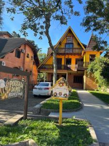 a yellow house with a sign in front of it at Pousada do Mel in Gramado