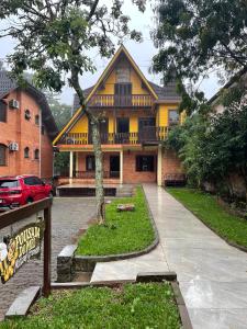 a yellow house with a sign in front of it at Pousada do Mel in Gramado