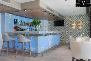 a bar with two chairs and a blue wall at Melia Alicante in Alicante