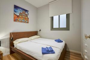 um quarto com uma cama com toalhas azuis em Quiet Luxury 2-bed apartment for couples & families em Barcelona