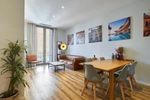 uma sala de estar com uma mesa e cadeiras e um sofá em Quiet Luxury 2-bed apartment for couples & families em Barcelona