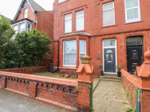 une maison en briques rouges avec une porte noire dans l'établissement Apartment 3, à Lytham St Annes