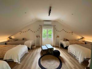 un dormitorio en el ático con 3 camas y una ventana en Domaine de 6 hectares avec 2 étangs que pour vous, en Nontron