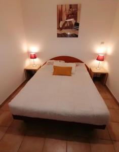 ein Schlafzimmer mit einem großen weißen Bett mit zwei Lampen in der Unterkunft MAISON ALBA ROSSA 55 in Serra-di-Ferro