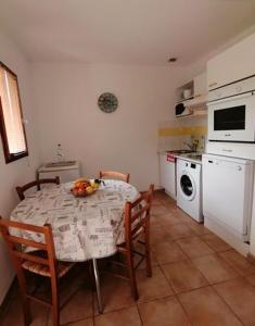 une cuisine avec une table et des chaises et une cuisine avec un four micro-ondes dans l'établissement MAISON ALBA ROSSA 55, à Serra-di-Ferro