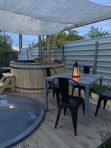 eine Terrasse mit einem Tisch und Stühlen auf einer Terrasse in der Unterkunft Dock Cottage House in Bădeni