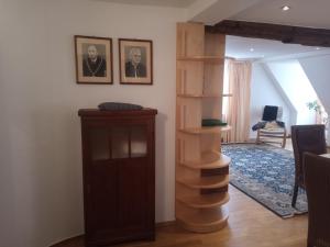a living room with a wooden book shelf and a staircase at Hotel-Restaurant Goldenes Lamm in Dinkelsbühl