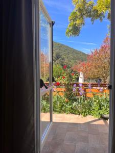 an open door with a view of a garden at La Fucinaia Pet Friendly B&B in Campiglia Marittima