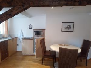 - une cuisine avec une table et des chaises dans la chambre dans l'établissement Hotel-Restaurant Goldenes Lamm, à Dinkelsbühl