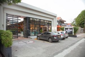 two cars parked in a parking lot in front of a store at Hotel Vanguardia Natural in Villavicencio
