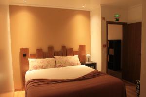 a bedroom with a large bed with a wooden headboard at Casa do Centro in Pessegueiro