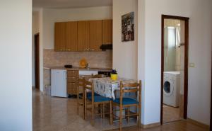 a kitchen with a table and chairs and a refrigerator at Calypso in Kaštela