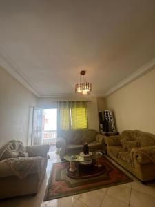 ein Wohnzimmer mit 2 Sofas und einem Tisch in der Unterkunft مدينة أصيلة قرب طريق السيار طنجة المغرب in Asilah