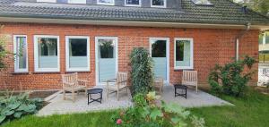 a brick house with chairs and a table in the yard at Gästehaus "Alte Bücherei" Satrup in Mittelangeln