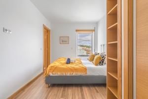 Schlafzimmer mit einem Bett und einem Fenster in der Unterkunft Apartamento Figueiras in Nazaré