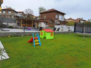 um parque infantil com escorrega e uma casa de brincar em Sunset view guest house em Ilindentsi