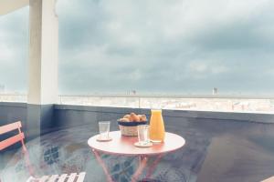 une table avec un panier de nourriture et deux verres dans l'établissement Le Rose - Centre Ville - Wifi, à Dunkerque