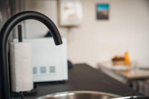 a kitchen counter with a sink and a faucet at Le Rose - Centre Ville - Wifi in Dunkerque +26 photos
