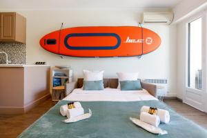 um quarto com uma prancha de surf pendurada na parede em Les 3 Palmiers YourHostHelper em Cannes