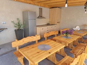 a dining room with wooden tables and a kitchen at Sunset view guest house in Ilindentsi