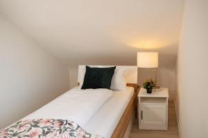 a small bedroom with a white bed and a lamp at Pension Zur Mühle in Grifte