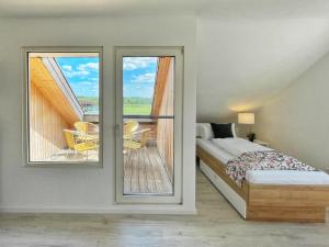 a bedroom with a bed and a balcony with a table at Pension Zur Mühle in Grifte