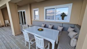 een eetkamer met een witte tafel en stoelen bij Villa Kalamos, beachfront in Pogoniá