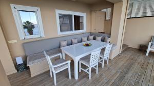 een witte tafel en stoelen in een kamer bij Villa Kalamos, beachfront in Pogoniá +35 foto's