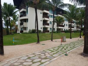 ein Park mit Palmen und ein Gebäude in der Unterkunft Estúdio equipado no Marulhos com vista do mar e do parque aquático, à beira-mar de Muro Alto, com restaurante, estacionamento e wi-fi, a 10 minutos de carro de Porto de Galinhas in Porto De Galinhas