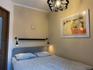Dormitorio con cama y póster en la pared en Apartament Bankowa Klimt, en Toruń